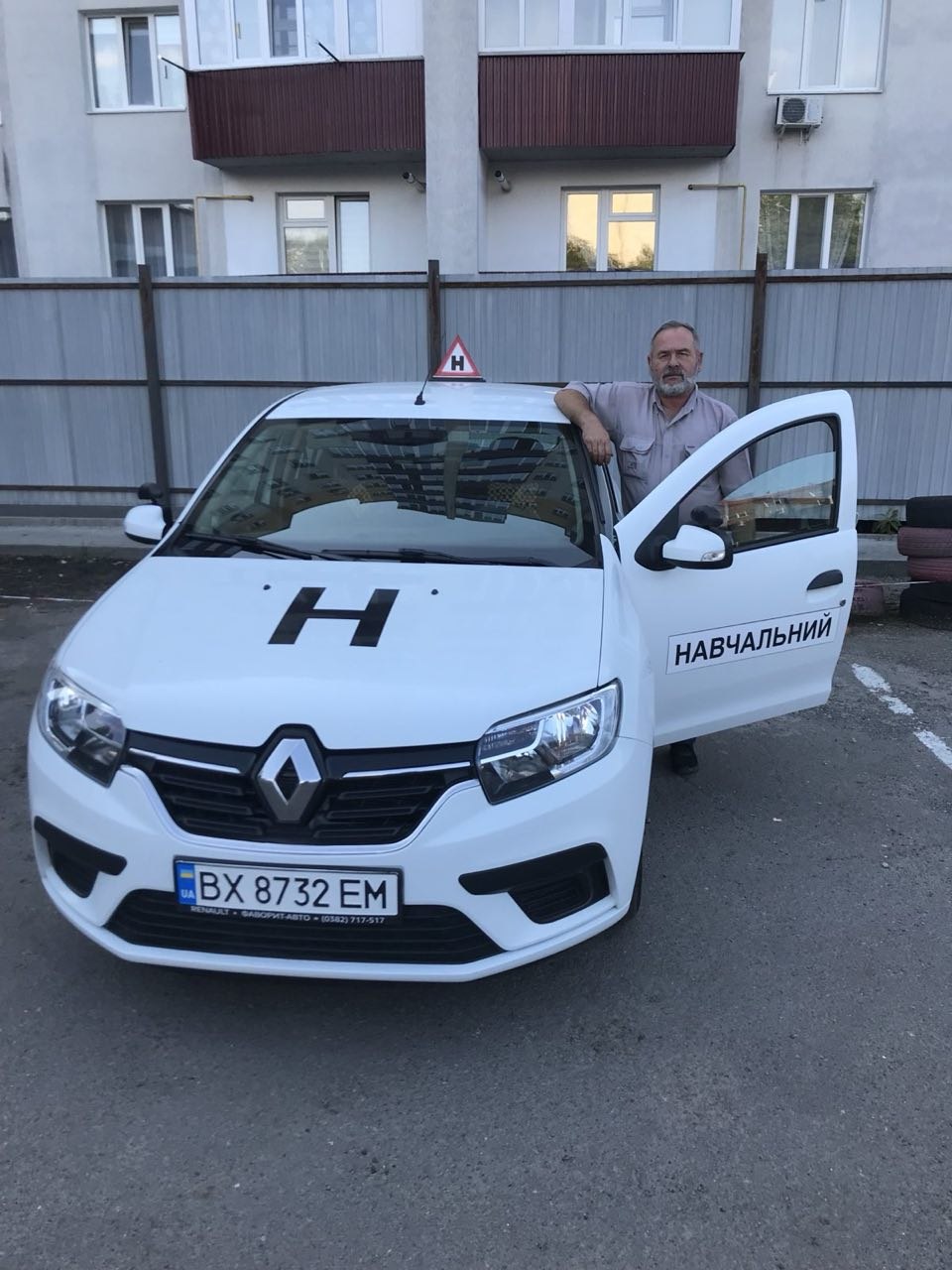 Інструктор автошколи Хмельницька ОТШ ТСОУ біля навчального Renault Sandero у Хмельницькому