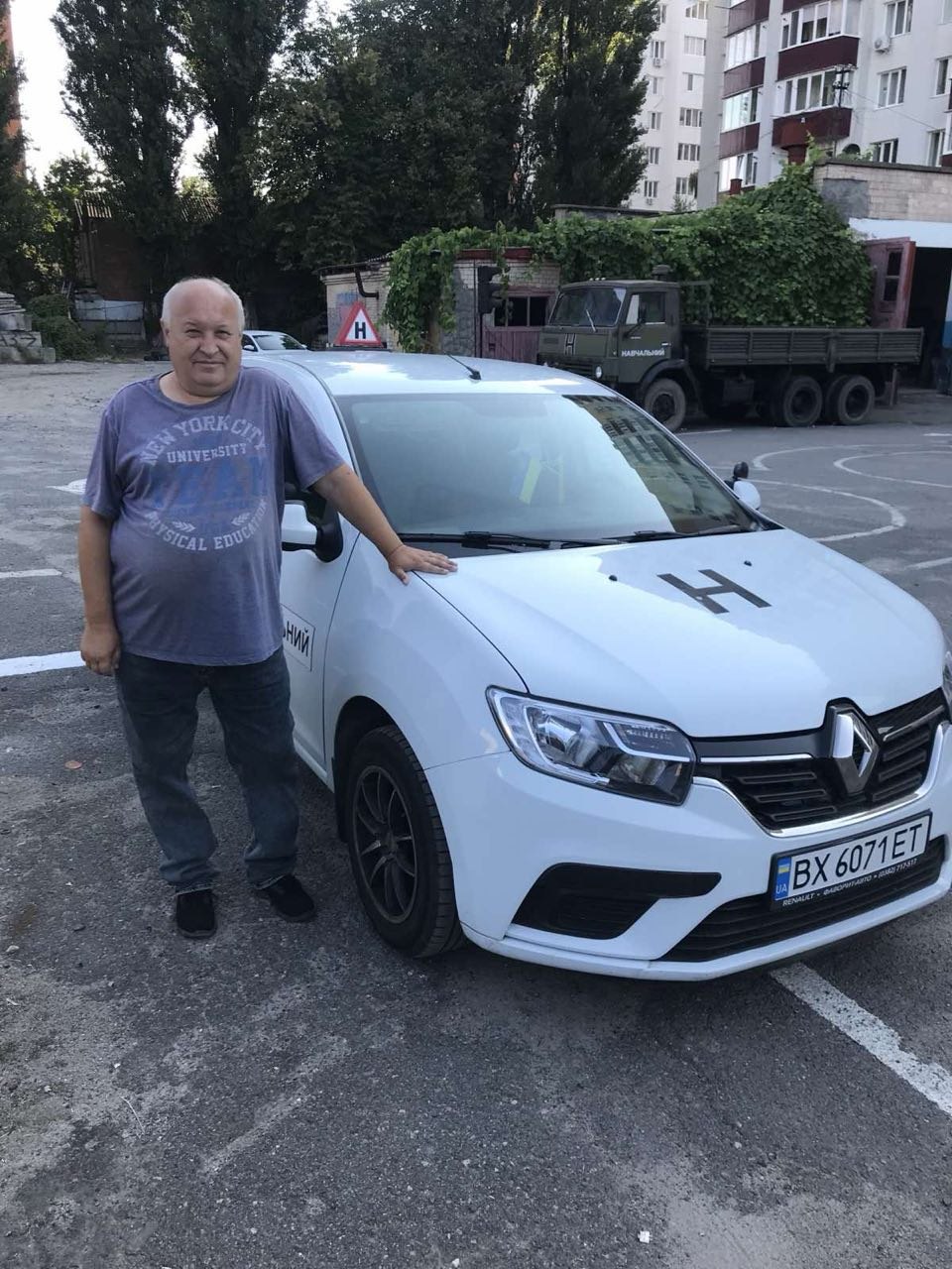 Інструктор автошколи Хмельницька ОТШ ТСОУ біля навчального Renault Logan у Хмельницькому